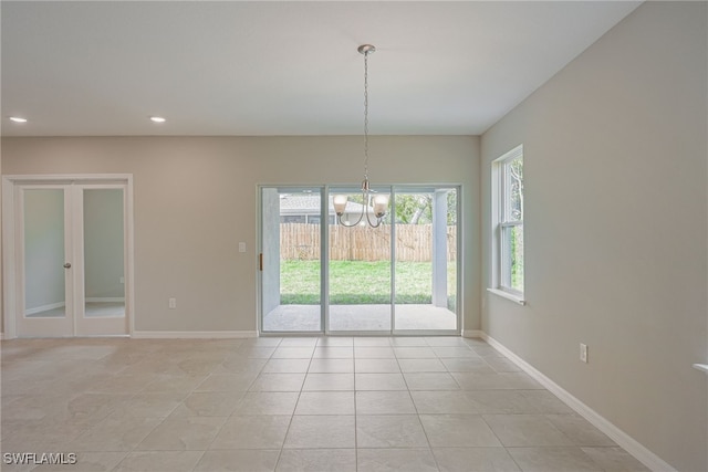 unfurnished dining area featuring light tile patterned floors and an inviting chandelier