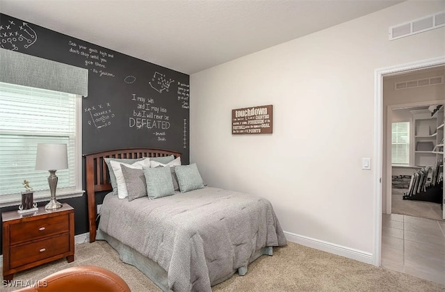 bedroom with light colored carpet and multiple windows