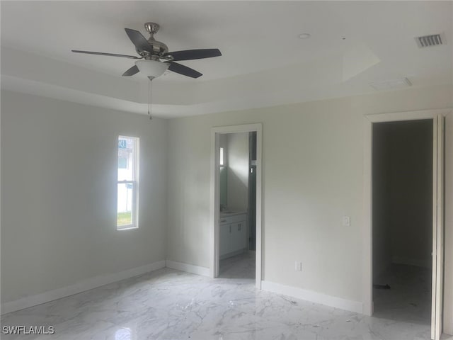 unfurnished room featuring ceiling fan and a tray ceiling