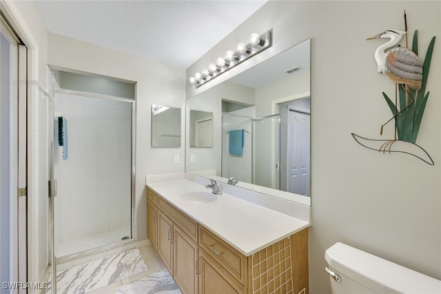 bathroom featuring a textured ceiling, toilet, a shower with door, and vanity