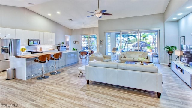 living room with ceiling fan and high vaulted ceiling