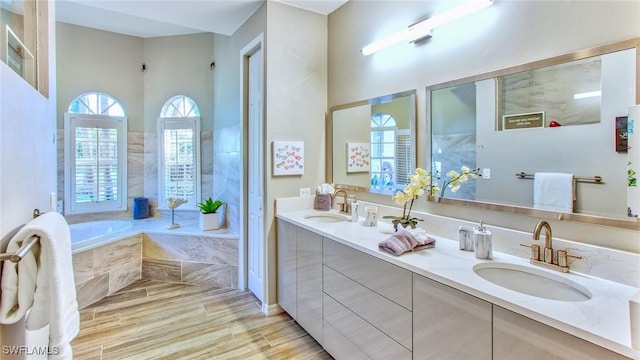 bathroom with tiled bath and vanity