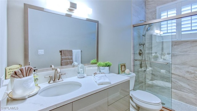 bathroom with toilet, vanity, and an enclosed shower