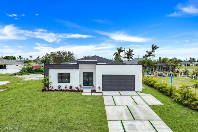 view of front of house featuring a garage, a front yard, concrete driveway, and stucco siding