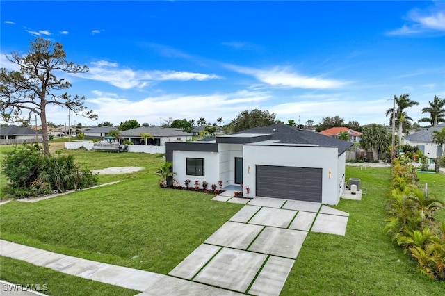 view of front of house with an attached garage, a front lawn, concrete driveway, and stucco siding