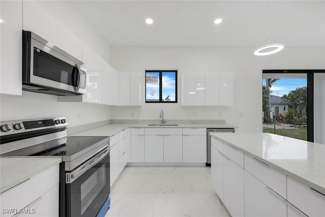 kitchen featuring white cabinets, modern cabinets, appliances with stainless steel finishes, marble finish floor, and a sink