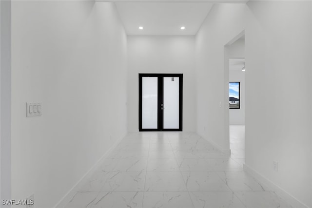 corridor with marble finish floor, recessed lighting, baseboards, and french doors