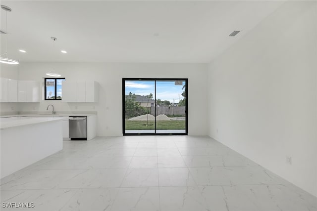 kitchen with marble finish floor, stainless steel dishwasher, light countertops, and white cabinets