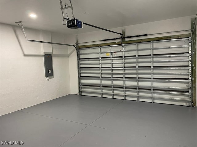 garage with a textured wall, electric panel, and a garage door opener