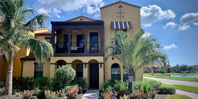 view of front facade with a water view and a balcony