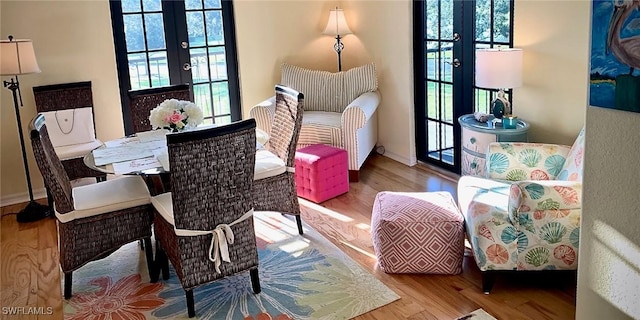 living area featuring french doors, a wealth of natural light, and light hardwood / wood-style floors