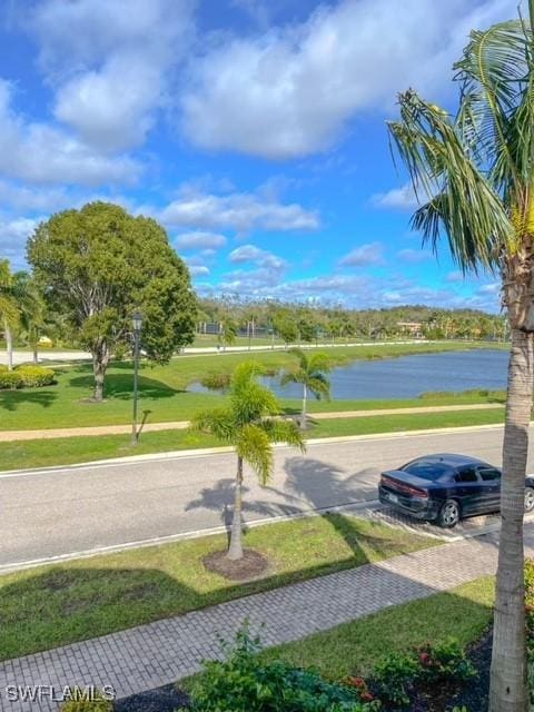 view of property's community with a water view and a yard