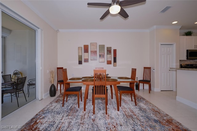 dining space featuring ceiling fan, light tile patterned floors, and ornamental molding