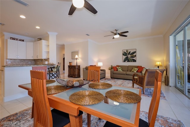 dining room with light tile patterned flooring, ceiling fan, ornamental molding, and sink