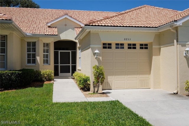 mediterranean / spanish home with a front lawn and a garage