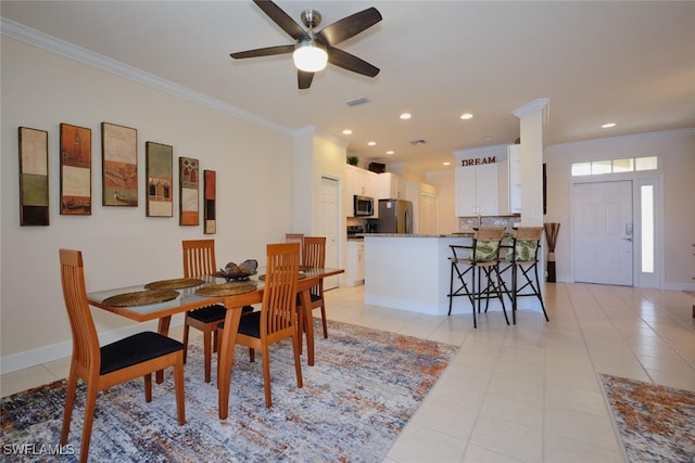 tiled dining room featuring ceiling fan and crown molding