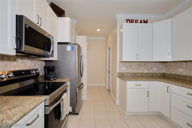 kitchen featuring light stone countertops, appliances with stainless steel finishes, white cabinetry, and ornamental molding