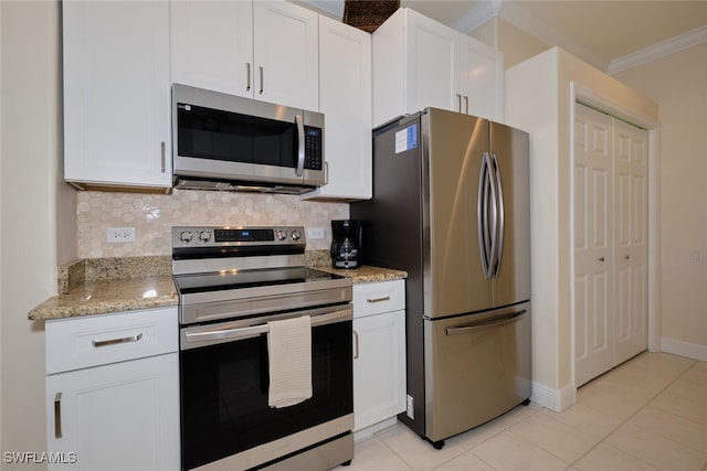 kitchen with white cabinetry, light tile patterned floors, ornamental molding, and stainless steel appliances