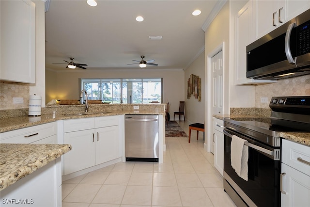 kitchen with sink, stainless steel appliances, ornamental molding, white cabinets, and light stone counters