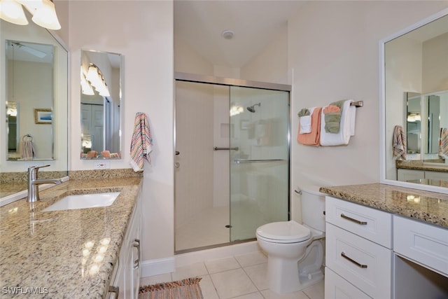 bathroom featuring toilet, tile patterned floors, vanity, and an enclosed shower