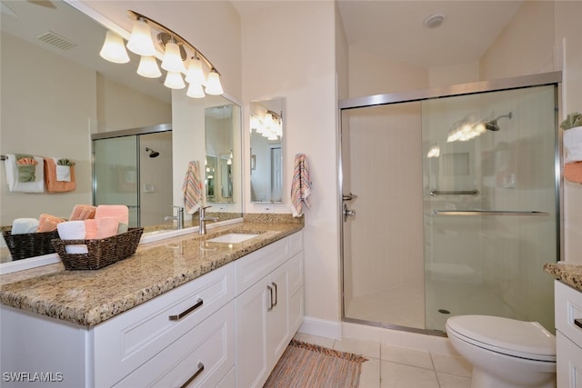 bathroom featuring toilet, tile patterned flooring, walk in shower, and vanity