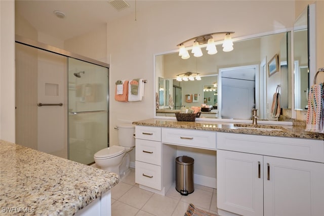 bathroom featuring toilet, tile patterned floors, walk in shower, and vanity