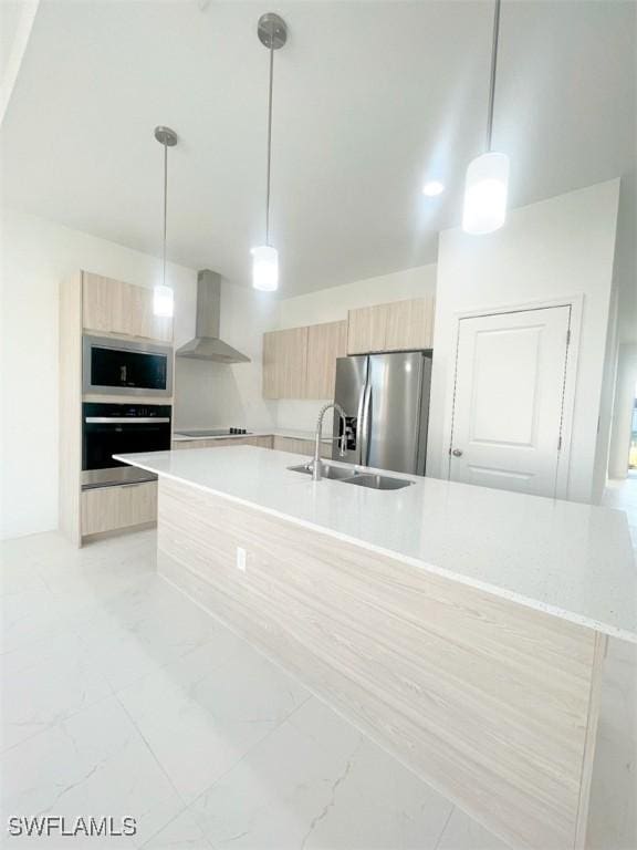 kitchen with stainless steel appliances, light countertops, light brown cabinets, wall chimney range hood, and modern cabinets