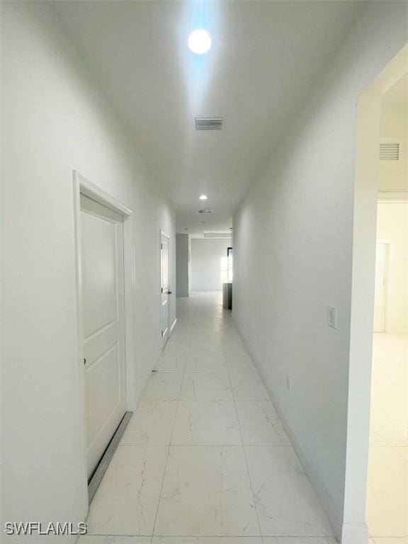 hall with recessed lighting, marble finish floor, and visible vents