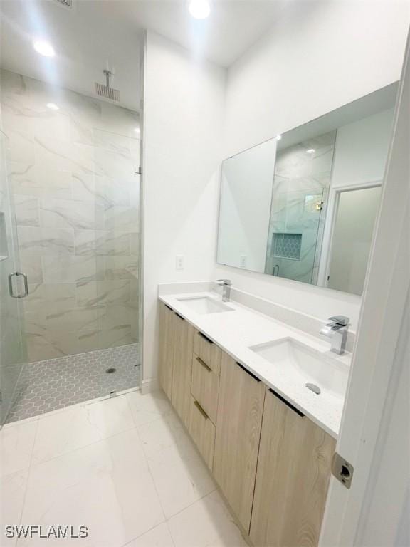 bathroom featuring marble finish floor, a sink, and a marble finish shower