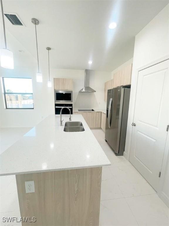 kitchen with stainless steel appliances, visible vents, light brown cabinets, modern cabinets, and wall chimney exhaust hood