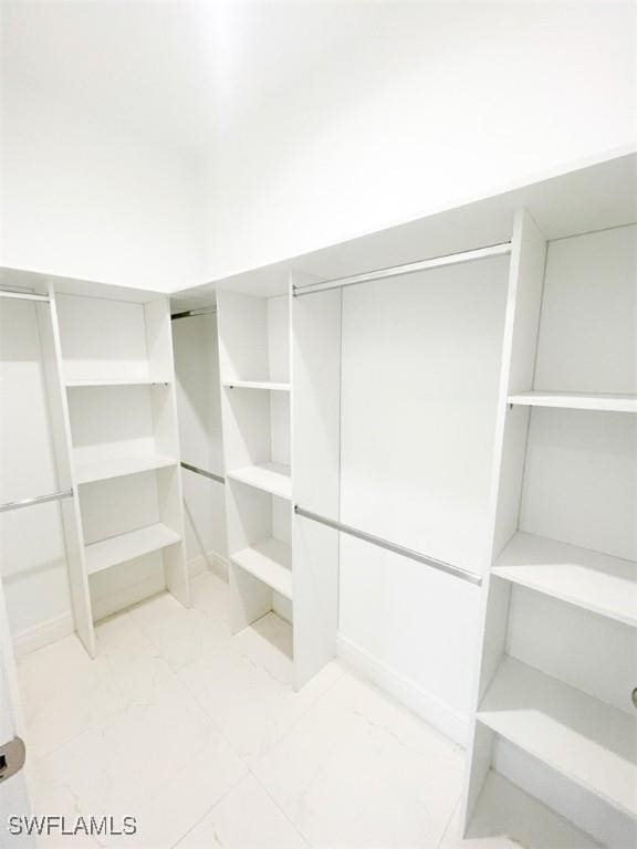 walk in closet with marble finish floor