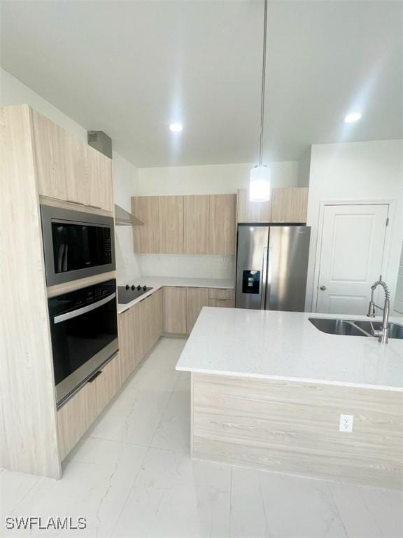 kitchen with modern cabinets, appliances with stainless steel finishes, marble finish floor, light brown cabinetry, and a sink