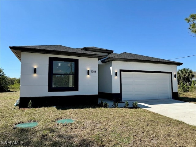 view of front of home featuring stucco siding, a shingled roof, a front yard, a garage, and driveway