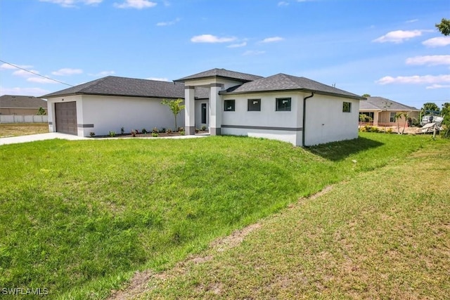 prairie-style house featuring a garage and a front lawn