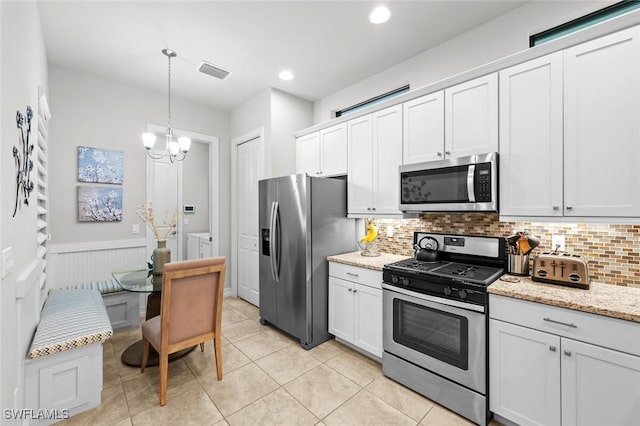 kitchen with white cabinets, washer and clothes dryer, and stainless steel appliances