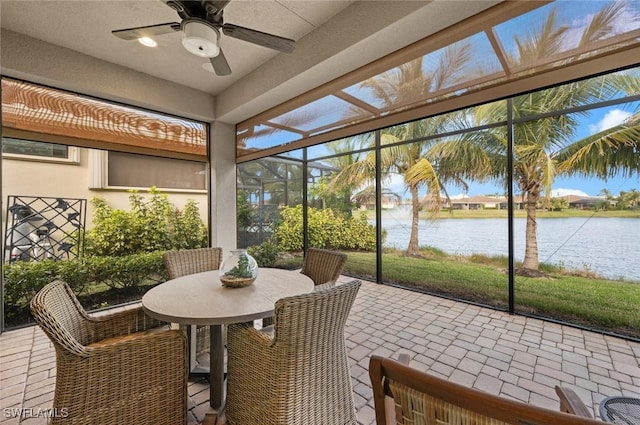 sunroom / solarium featuring a water view and ceiling fan