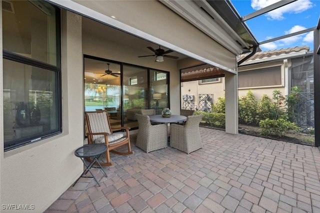 view of patio / terrace featuring ceiling fan and a lanai