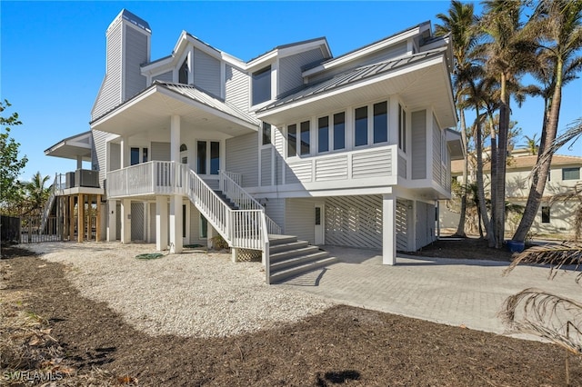 raised beach house featuring covered porch