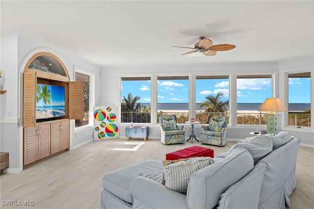 living room with ceiling fan, a healthy amount of sunlight, light hardwood / wood-style floors, and crown molding