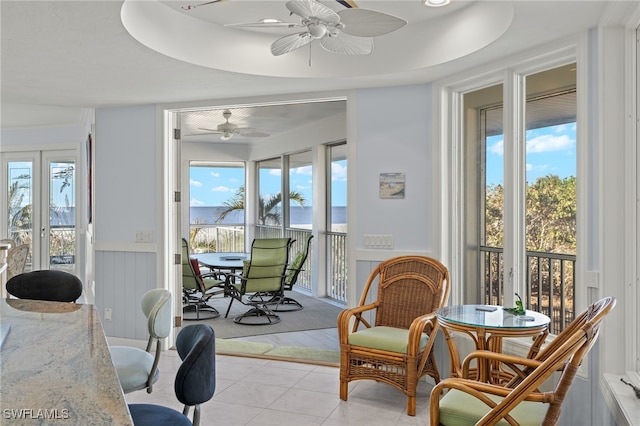 sunroom / solarium featuring a raised ceiling and ceiling fan