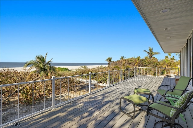 deck featuring a beach view and a water view