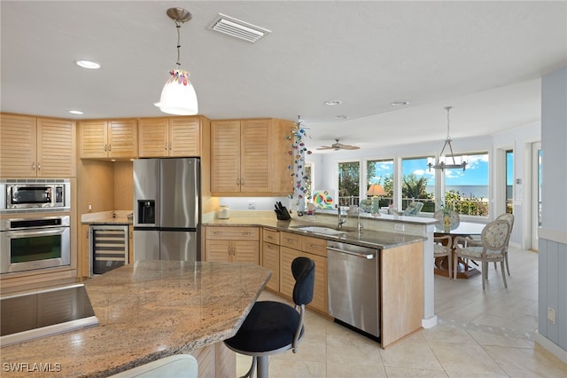 kitchen featuring kitchen peninsula, stainless steel appliances, light brown cabinetry, wine cooler, and sink