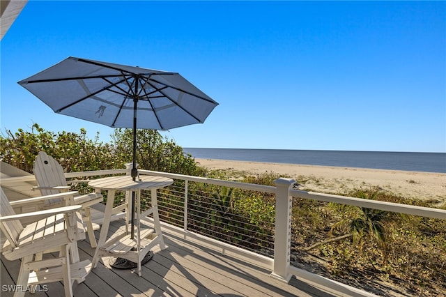 wooden deck featuring a water view and a beach view