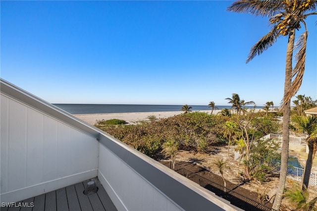 balcony featuring a view of the beach and a water view