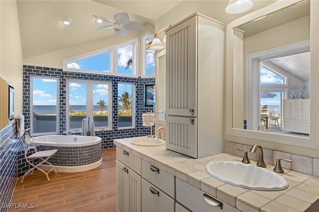 bathroom with hardwood / wood-style flooring, vanity, lofted ceiling, and ceiling fan