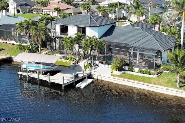 view of dock featuring glass enclosure, boat lift, a water view, a residential view, and a patio area