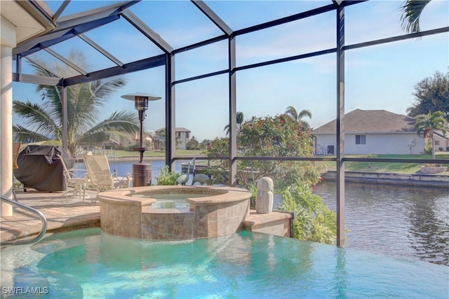 view of swimming pool with glass enclosure, a patio, a water view, and a pool with connected hot tub