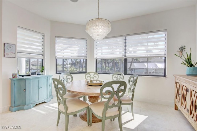 dining area featuring a chandelier, baseboards, and light tile patterned floors