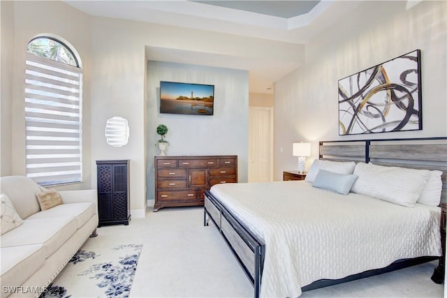 bedroom with light carpet and baseboards