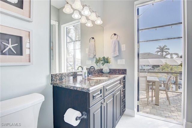 bathroom featuring vanity, toilet, and an inviting chandelier